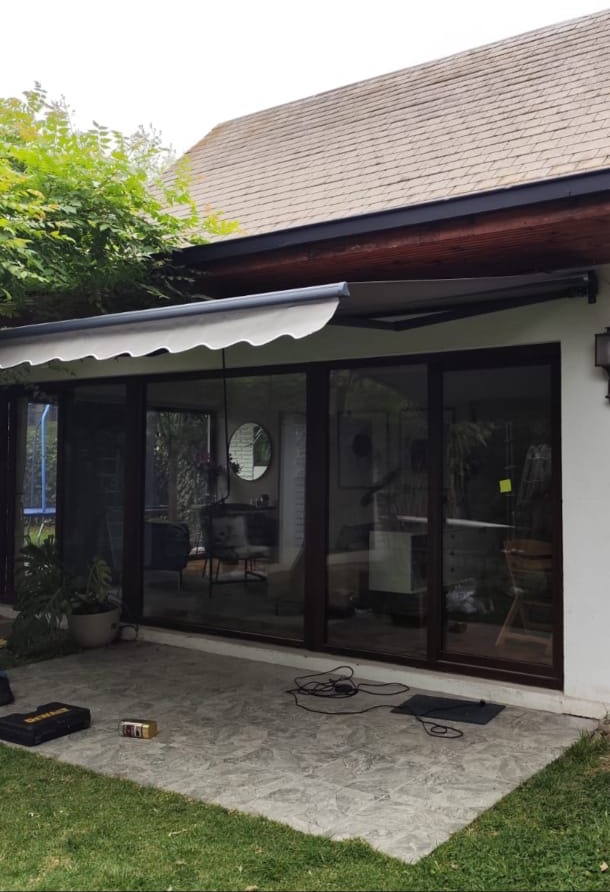 Toldo retráctil gris instalado en una terraza residencial